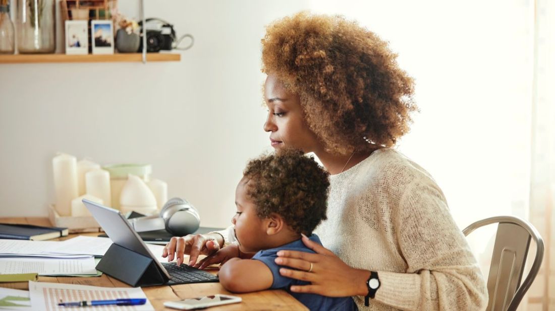 A picture of a woman and child looking at a laptop